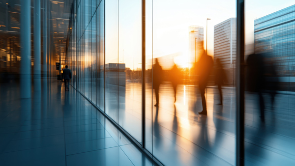 people walking in a modern urban setting with glass reflections and sunset light showcasing movement and city atmosphere related to business and collaboration 2